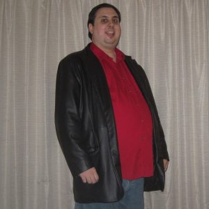 Side view of Marco Orlando. Marco wears a red shirt and black leather jacket. Marco has dark brown hair.