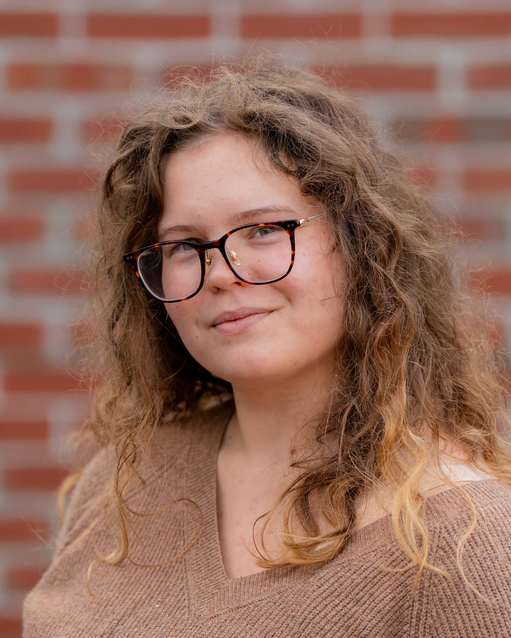 Megan, a white woman with curly red hair and large square glasses.