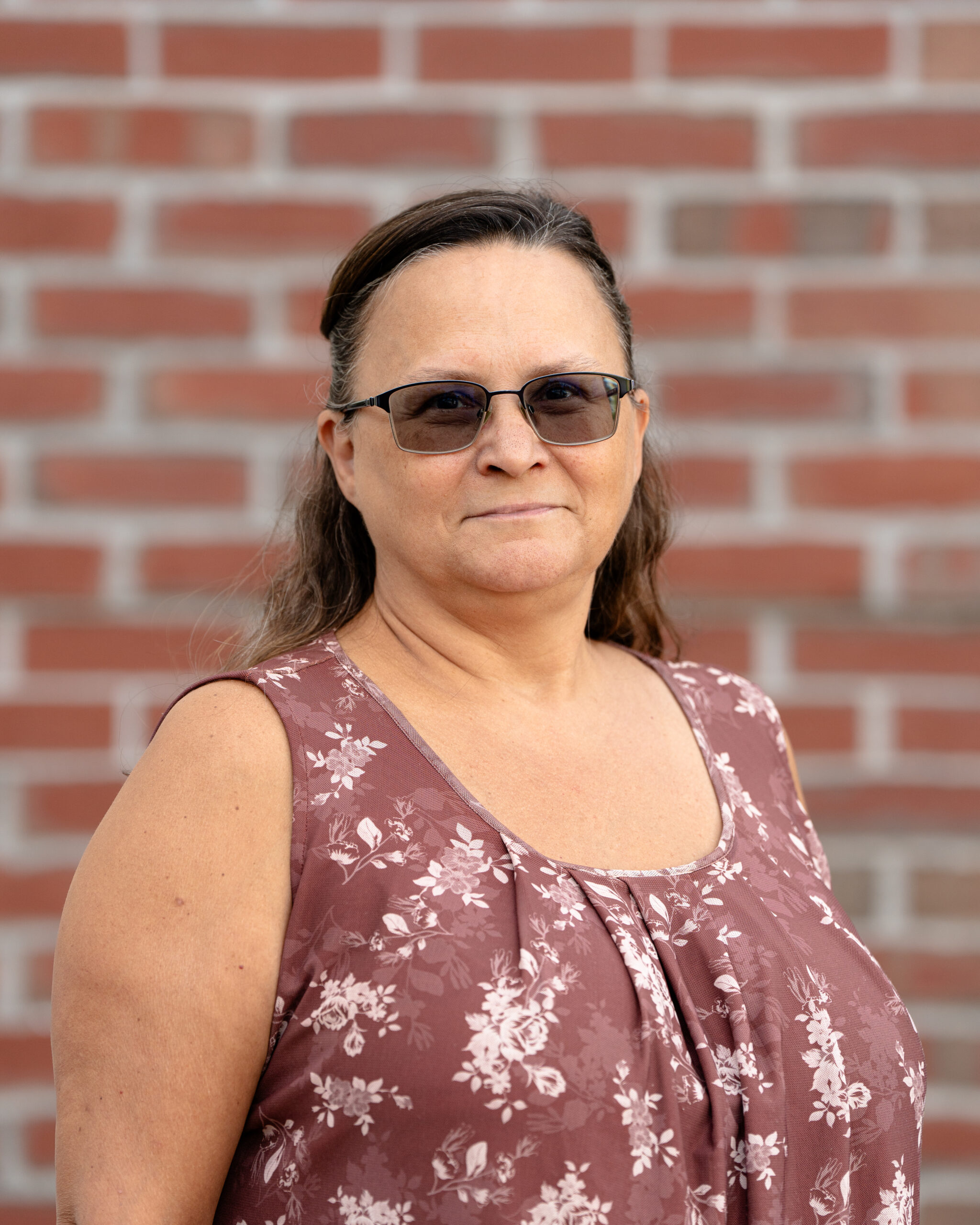 Tammy is a white woman with shoulder -length brown hair and brown eyes. She also wears glasses.