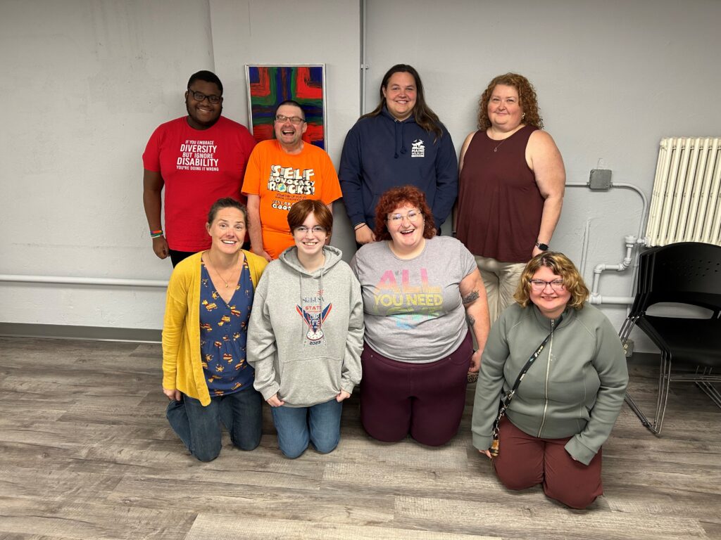 Group of 8 participants in the train-the-trainer series. They stand in two rows.