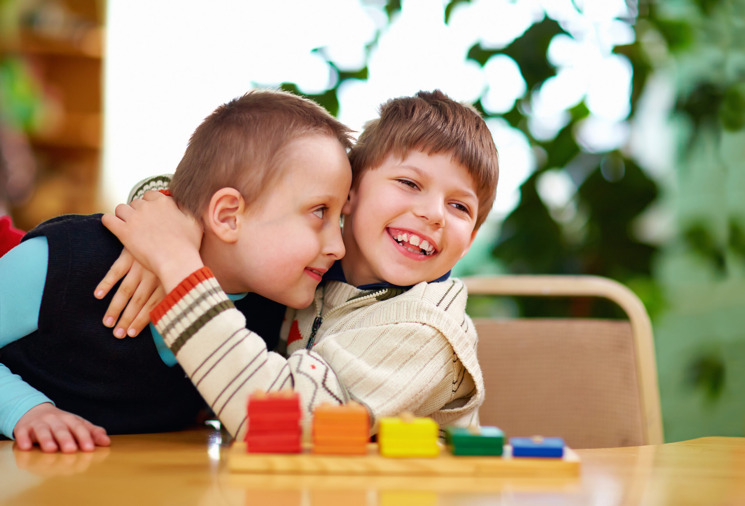 Two white children hug sideways.