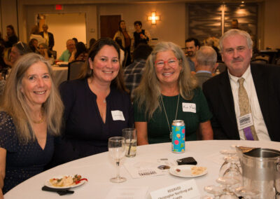 Group of four people smile at DRM celebration.